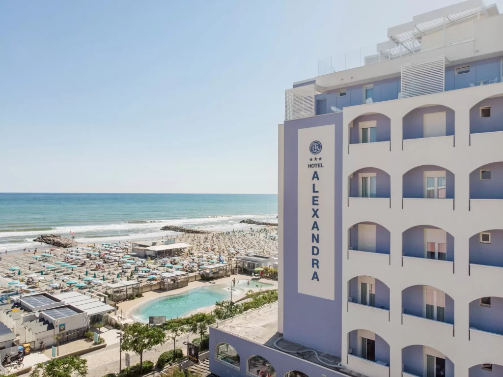 Vista di un hotel sul mare con spiaggia e piscina.