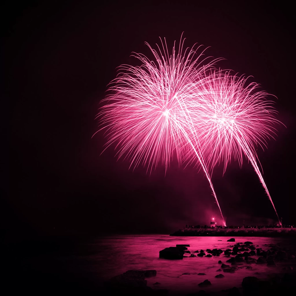 Fuochi d'artificio rosa sul mare di notte.