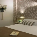 Camera da letto elegante con decorazioni geometriche e libro appoggiato sul letto.