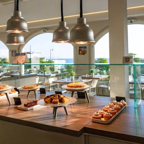 Buffet di dolci in un ristorante con vista sul mare.