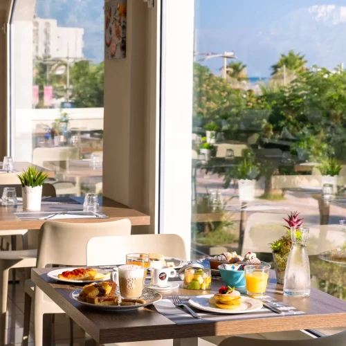 Tavolo da colazione in un ristorante luminoso con vista sul giardino.