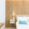 Camera da letto moderna con pareti in legno e dettagli bianchi e azzurri.