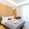 Camera da letto moderna con letto matrimoniale, parete in legno e arredi eleganti.